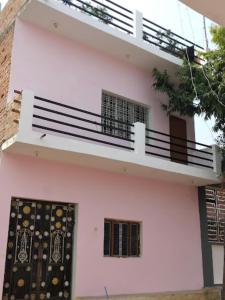 een wit huis met een balkon en een deur bij Goroomgo Hotel Happy Home Stay Khajuraho in Khajurāho