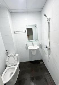 a white bathroom with a toilet and a sink at Hanoi Capsule Station Hostel in Hanoi