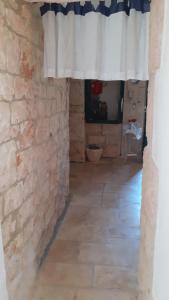 een kamer met een stenen muur en een gordijn bij Trullo Oasi di Pace in Ceglie Messapica