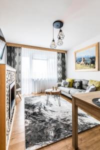 salon z kanapą i stołem w obiekcie Apartament Regionalny Centrum w Zakopanem