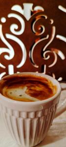 a cup of coffee sitting on a table at Hotel Ansi Boutique W&S terrace in Bukhara