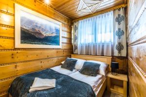 sypialnia z łóżkiem w drewnianym domku w obiekcie Apartament Regionalny Centrum w Zakopanem