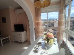 a room with a table with a vase of flowers on it at Canoa in Torrox Costa