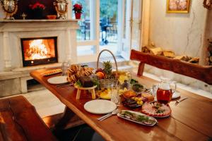 a table with food on it in a living room with a fireplace at Knyazheska Banya in Sofia