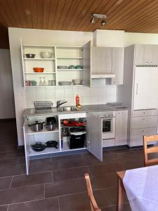 una cucina con armadi bianchi e lavandino di APARTAMENT ROSY a Interlaken