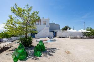 a group of green plastic trees in a parking lot at Tenuta Miro in Ostuni