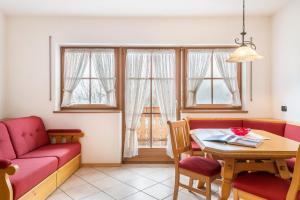un soggiorno con divano rosso e tavolo di Apartments Mirabell a Livinallongo del Col di Lana