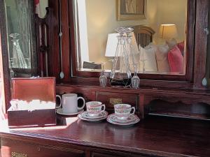 a wooden table with two cups and a mirror at Inkungu Lodge in Champagne Valley
