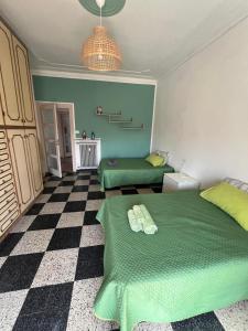 1 dormitorio con 2 camas verdes y suelo a cuadros en Casa GIULIVA, en Alessandria