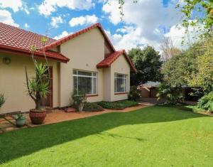 a house with a green lawn in front of it at Lovely Holiday in Kempton Park