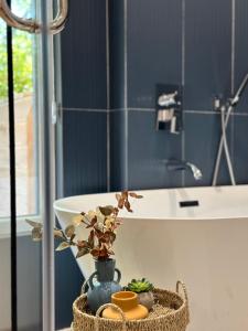 a bathroom with a sink and a basket with a plant at Hotel Restaurant Natyra e Qetë in Lezhë