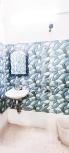 een badkamer met een witte wastafel en een muur met een golfpatroon bij Jerry Residency - foregner Friendly Luxury Rooms in New Delhi