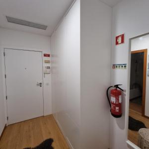 um quarto branco com um extintor de incêndio na parede em Quinta da Barca Resort em Gandra