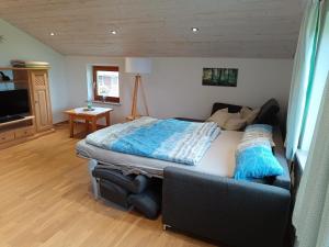 ein Schlafzimmer mit einem Bett und einem Sofa in der Unterkunft Ferienwohnung auf dem Land in Tuntenhausen