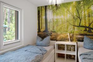 a bedroom with a forest mural on the wall at Müritzblick in Vipperow
