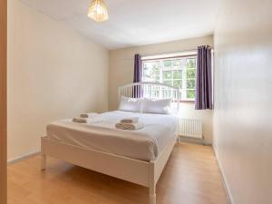 a white bed in a room with a window at Pass the Keys Large house in Benfleet in South Benfleet