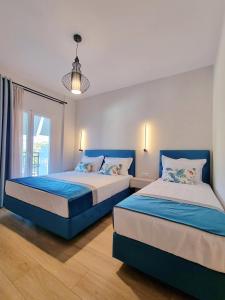two beds in a bedroom with a window at Studios Despina in Limenaria