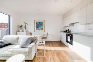 a white living room with a couch and a kitchen at Central Bournemouth Apartment, Balcony, Free Parking in Bournemouth