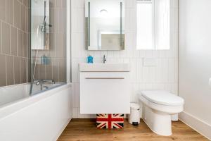 a white bathroom with a toilet and a sink at Central Bournemouth Apartment, Balcony, Free Parking in Bournemouth +23 photos