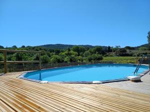 una piscina en la parte superior de una terraza de madera en La ferme d'Andréa au milieu des vignes à 3min à pied du centre piscine chauffée climatisation, en Lourmarin