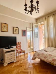 una camera con letto, TV e sedia di Mint Apartment a Tivat