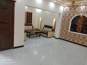 uma sala de espera com cadeiras e um quadro na parede em Shah jee guest house em Jhelum