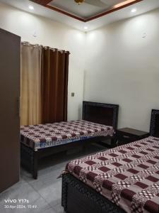 um quarto com duas camas e uma cortina em Shah jee guest house em Jhelum