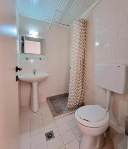 a bathroom with a toilet and a sink at Studios Despina in Limenaria