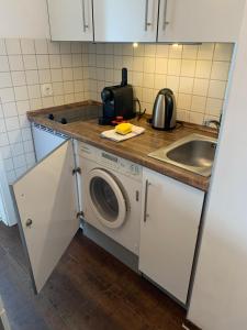 eine Küche mit einer Waschmaschine und einem Waschbecken in der Unterkunft Business Apartment SPA walk to Fair & Rhine River in Düsseldorf