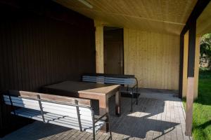 una veranda con panchina, tavolo e porta di Chatka na hřišti TJ Sokol a Ostravice