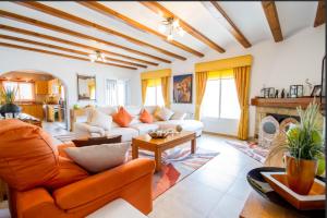 ein Wohnzimmer mit einem Sofa und einem Tisch in der Unterkunft Villa El Huerto in Orba