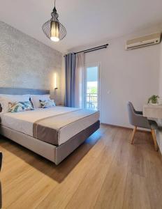 a bedroom with a large bed and a balcony at Studios Despina in Limenaria