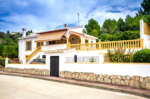 een wit huis met een balkon en een hek bij Villa El Huerto in Orba