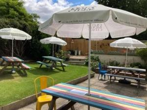 2 Picknicktische mit Sonnenschirmen im Garten in der Unterkunft The Cottage Upstairs at The Green Man, Ropsley in Ropsley