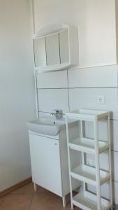 biała łazienka z umywalką i półką w obiekcie Zimmer im Ferienpark Buntspecht w mieście Pruchten