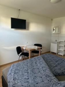 1 dormitorio con 1 cama y 1 mesa con sillas en Zimmer im Ferienpark Buntspecht, en Pruchten