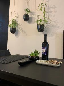 a black table with a bottle of wine and plants at IL GINEPRO house in Cagliari