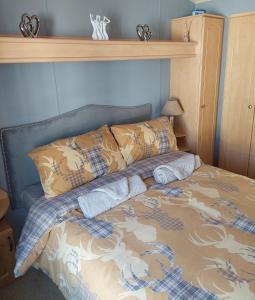 Una cama con dos almohadas encima. en Wright Choice caravan rental 5 Lunan View St Cyrus Caravan Park, en Saint Cyrus