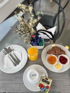 Hotel Costanera في بويرتو ناتالز: طاولة عليها أطباق من طعام الإفطار