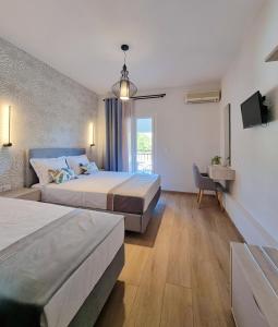 a hotel room with two beds and a tv at Studios Despina in Limenaria +22 photos