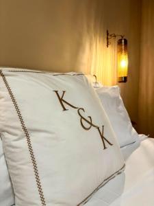 een kussen met de letter k erop op een bed bij OIA UNIQUE HOMES by K&K in Oia +204 foto's