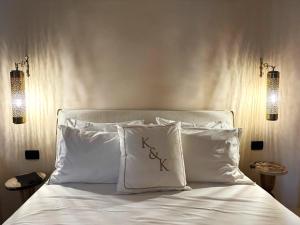 a bed with two white pillows and two lights at OIA UNIQUE HOMES by K&K in Oia