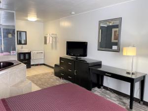 sypialnia z łóżkiem, telewizorem i umywalką w obiekcie Wooden Shoe Motel w mieście Holland