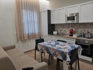 een keuken met een tafel en stoelen in een kamer bij Palazzo Buscema - Casa & Vacanza in Crotone