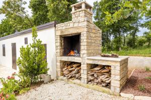 a stone fireplace with a pile of fire wood at Casa Mirna for 7 people near Pula with sea view & only 2 km from the sea in Peruški
