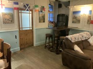 a living room with a table and a couch at Wayfarer Inn in Instow