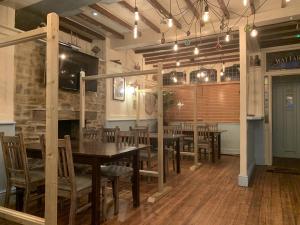 a dining room with tables and chairs and a fireplace at Wayfarer Inn in Instow