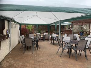 a patio with tables and chairs under a tent at Wayfarer Inn in Instow