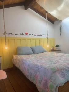 a bedroom with a bed with a sign on the wall at Pousada Villa Del Bosque in Monte Verde