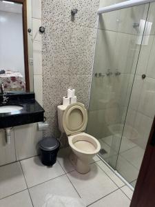 a bathroom with a toilet and a glass shower at Pousada Bella Vista in Aparecida +70 photos